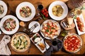 Big dinner table with italian food, pizzas and pastas