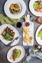 Big dinner table overhead view with steak and fish Royalty Free Stock Photo