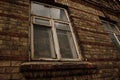 Big dirty window in old dark brick wall with a sill