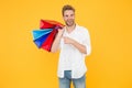 Big discount. Happy man holding purchases in paper bags. If I want I will get. Bachelors day. Consumerism concept