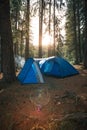 Big dome and camping tent with vestibule. Warm sun rays. Tourist camp among tall pines. Smoke from the fire. Tent. lake shore Royalty Free Stock Photo