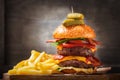 Big double hamburger with cheese, bacon, salad, vegetables and french fries Royalty Free Stock Photo