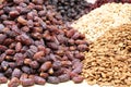 Big dried dates, raw almonds and pistachios, lying on a large counter at the market in Deira, Dubai