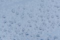 Big drops of rain on a car bonnet, the texture of paint is blue metallic Royalty Free Stock Photo