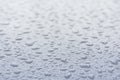 Big drops of rain on a car bonnet, the texture of paint is blue metallic Royalty Free Stock Photo