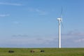 Dutch wind turbine near dike with parked cars