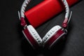 Big earphones of white and red colors. Small the portable speakers. Black background. Modern mobile electronics. Gadgets. Royalty Free Stock Photo