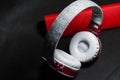 Big earphones of white and red colors. Small the portable speakers. Black background. Modern mobile electronics. Gadgets. Royalty Free Stock Photo