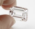 Big Emerald Cut Diamond Held Between Fingers