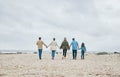 Big family, beach holiday and summer travel with child, parents and grandparents on sand and cloudy sky for love, care Royalty Free Stock Photo