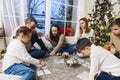 Big family gathering near Xmas tree playing lotto board game at home during Christmas holidays Royalty Free Stock Photo