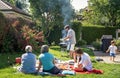 Big family having picnic and barbecue sitting on grass in garden at home at bright sunny day. Royalty Free Stock Photo