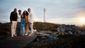 Big family, portrait walking and nature bonding on a holiday at sunset by a sea lighthouse. Ocean, beach walk and