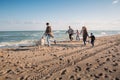 big multigenerational family running with labrador dog on beach Royalty Free Stock Photo