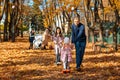 big family spends time together in autumn city park, children and parents, happy people walk and relax, ride scooters, beautiful Royalty Free Stock Photo