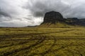 Big and famous moss covered flat mountain peak formation Lomagnupur in Iceland. Overcast sky and rainy weather