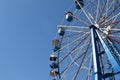 A big Ferris wheel with bright blue ky in the background.