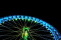 Big ferris wheel with festive green and blue illumination