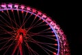 Big ferris wheel with festive red illumination against night sky. Royalty Free Stock Photo