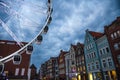 Big ferris wheel, tower, traditional typical facades of colorful buildings at pedestrian Stagiewna street at sunset, dusk, Royalty Free Stock Photo