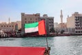 Big flag of United Arab Emirates flying high on city of Dubai in old town. Natoinal Day UAE. Royalty Free Stock Photo
