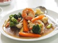 Big flat Fried noodle with seafood shrimp and kale soaked in gravy on white plate Royalty Free Stock Photo