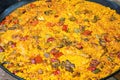 Big flat frying pan with home cooked Spanish paella. Variety of meat chicken, rabbit, vegetables, rice, tomato sauce, spices