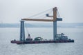 Big floating crane sailing near sea coast. Royalty Free Stock Photo