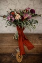 Big flover bouquet standing on the wooden crate with a key with an infinity sign on the trinkle in it Royalty Free Stock Photo