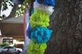 Big fluffy paper flower garland hanging at tree as part of wedding decoration