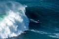 Big foamy waves of the Atlantic Ocean near the Nazare municipality in Portugal and surfers riding