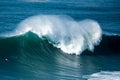 Big foamy waves of the Atlantic Ocean near the Nazare municipality in Portugal and surfers riding