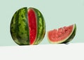 Big fresh watermelon and red slice of watermelon on table on neo mint colored background. Creative minimal summer fruit concept. Royalty Free Stock Photo