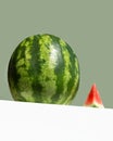 Big fresh watermelon and red slice of watermelon on table on neo mint colored background. Creative minimal summer fruit Royalty Free Stock Photo