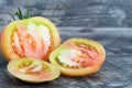 Big fresh yellow cut tomato isolated on wood background