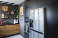 Fridge in black kitchen with wooden furniture red kitchen robot and white coffee machine