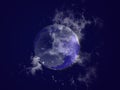 Big full blue moon silhouette in black cloudy sky. Moon covered with clouds. Moon, sky, cosmos, planets, nature, night. Royalty Free Stock Photo