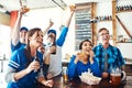 Big fun watching the big game. a group of friends cheering while watching a sports game at a bar. Royalty Free Stock Photo