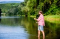 Big game fishing. relax on nature. mature bearded man with fish on rod. successful fisherman in lake water. hipster Royalty Free Stock Photo