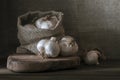 big Garlic Cloves and Bulb wooden table cooking on dark background. burlap sack cutting board copy space Close-up rustic still Royalty Free Stock Photo