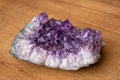 Big geode found in europe with white and purple crystals in the inside on wooden underground Royalty Free Stock Photo