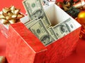 Big gift box with ribbon bow and stack of money, merry chirtmas and happy new year concept, closeup Royalty Free Stock Photo