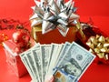 Big gift box with ribbon bow and stack of money, merry chirtmas and happy new year concept, closeup Royalty Free Stock Photo