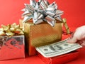 Big gift box with ribbon bow and stack of money, merry chirtmas and happy new year concept, closeup Royalty Free Stock Photo