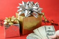 big gift box with ribbon bow and stack of money, merry chirtmas and happy new year concept Royalty Free Stock Photo