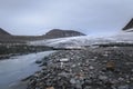 Big glacier in between mountain valley and river flowing fast with melted ice, Sarek, Sweden