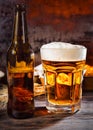 Big glass with freshly poured beer and head of foam near bottle Royalty Free Stock Photo