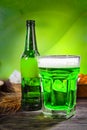 Big glass with freshly poured green beer and head of foam near b Royalty Free Stock Photo