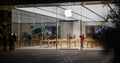 Big Glass Windows of Apple Store at night modern building people working on the computers Apple logo Royalty Free Stock Photo