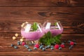 Big glasses with cocktails on a wooden background. Appetizing milkshake with blueberries, mint and peanuts. Copy space. Royalty Free Stock Photo